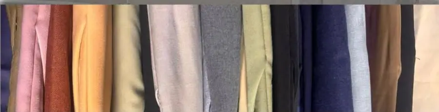Our trousers folded in more than 10 colours, from pink and rust to navy, grey and cream