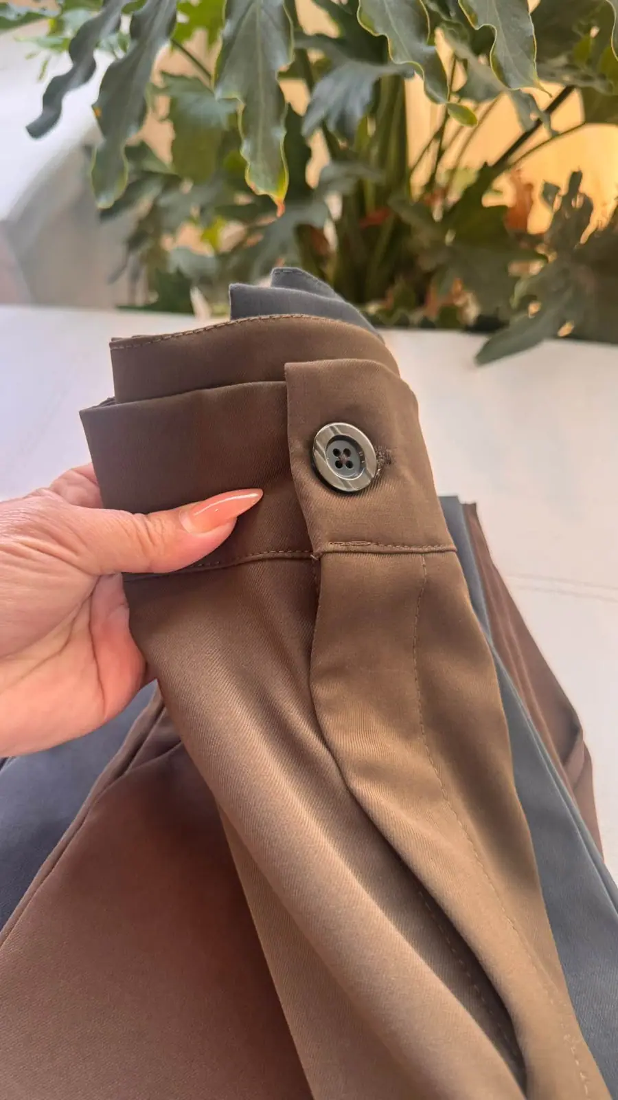 Close-up of a waistband tab with a horn-look button