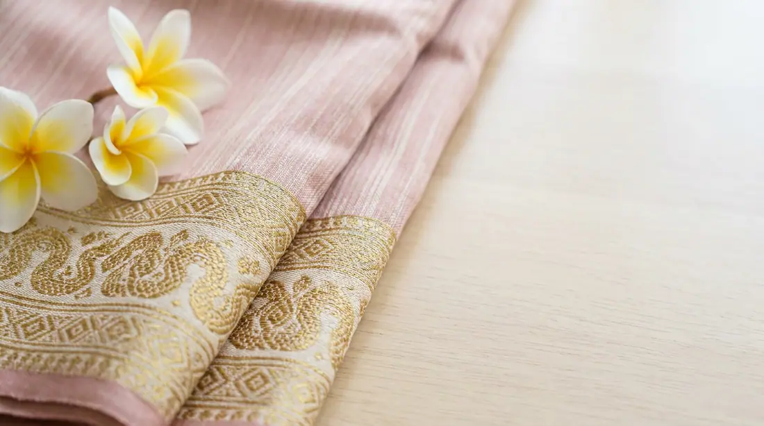 Lao silk with a gold naga border and champa flowers